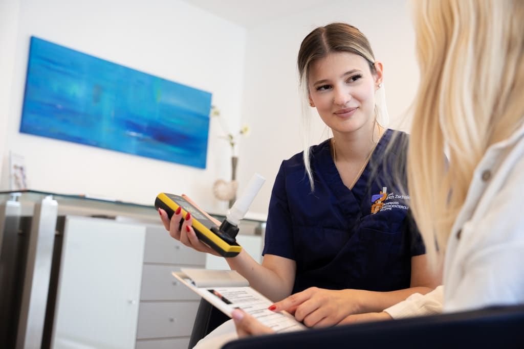 Eine Arzthelferin zeigt einer Patientin das Ergebnis eines Atemtests.
