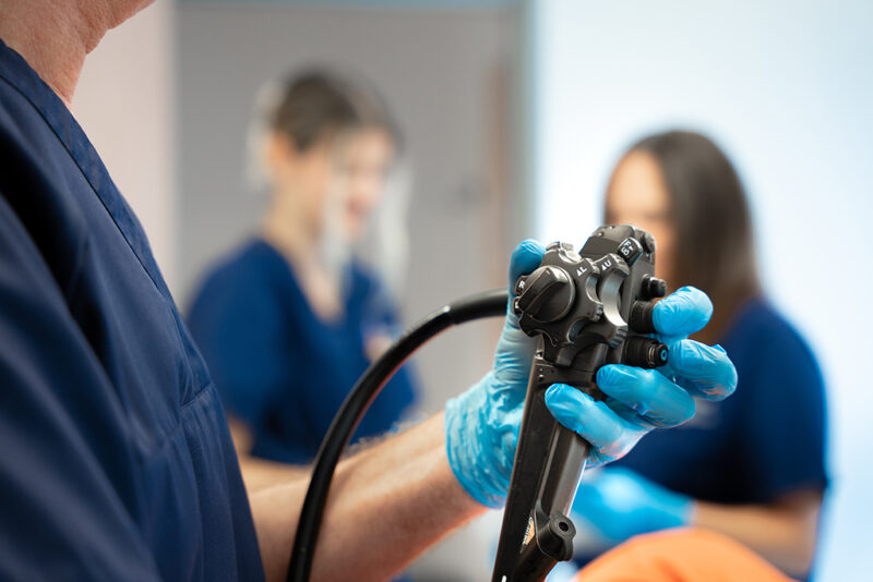 Arzt hält ein Proktoskopiegerät in den Händen